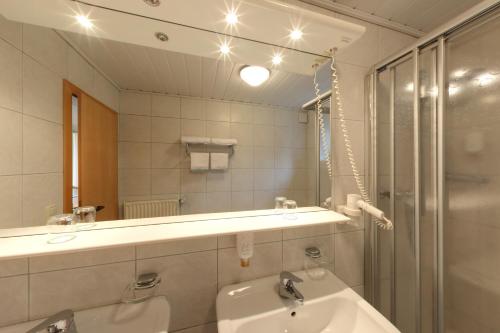 een badkamer met een wastafel en een spiegel bij Hotel Altes Gasthaus Greve in Recke