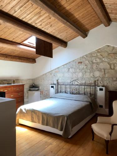 a bedroom with a bed and a stone wall at Le Tre Giare in Modica