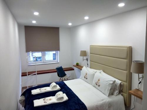 Una habitación de hotel con una cama con toallas. en ML Apartments Aliados, en Oporto