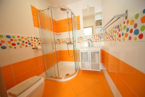 y baño blanco y naranja con ducha. en Apartment Leposa en Kranjska Gora