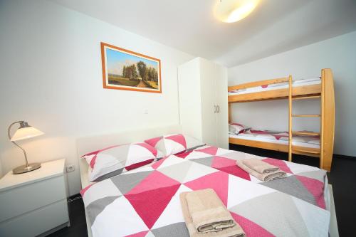 Schlafzimmer mit einem farbenfrohen Bett und Etagenbetten in der Unterkunft Apartment Leposa in Kranjska Gora