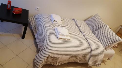 a bed with striped pillows and towels on it at Patras Palm Tree in Patra