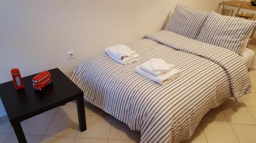 a bed with two pillows on it next to a table at Patras Palm Tree in Patra