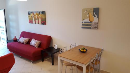 a living room with a red couch and a table at Patras Palm Tree in Patra