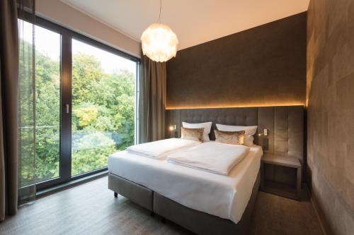 a bedroom with a bed and a large window at DECK 8 DESIGNHOTEL.SOEST in Soest