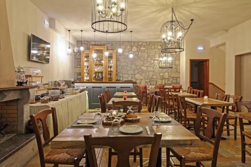 a dining room with tables and chairs and chandeliers at Arion Hotel in Delfoi