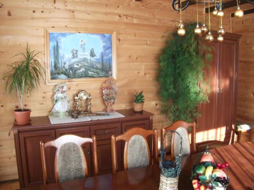 a dining room with a table and a painting on the wall at Karpatskyi Gomin in Vorokhta