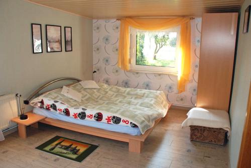 a small bedroom with a bed and a window at Ferienhaus Sehlen auf Ruegen in Sehlen