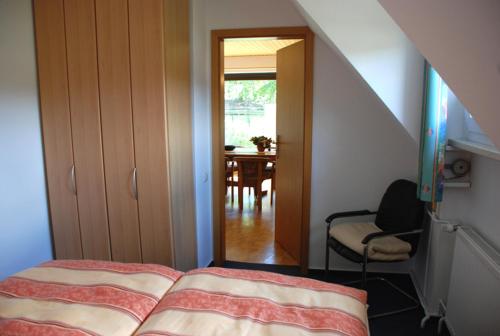 a bedroom with a bed and a dining room at Ferienappartements unterm Reetdach in Sandort