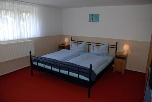 オストゼーバート・ゼリンにあるFerienwohnung Fam_ Biskupekのベッドルーム1室(ベッド1台付)、2泊分のスタンド(ランプ付)