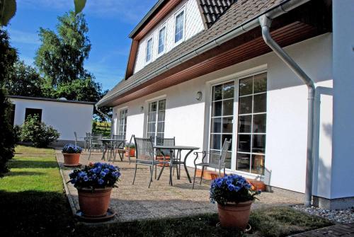 Casa con patio con mesa y sillas en Ferienwohnungen an der Hagenschen, en Middelhagen
