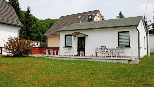 オストゼーバート・ゼリンにあるNEU _ Ferienhaus mit Sonnenterrasseの白い家(椅子付きのデッキ付)