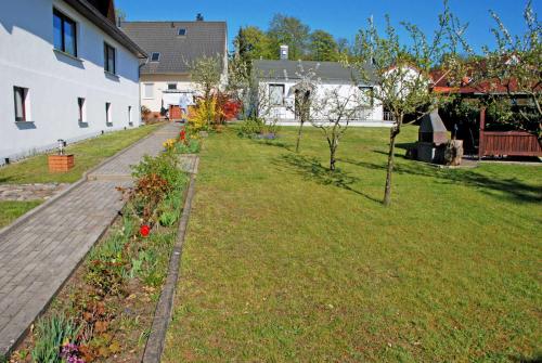 オストゼーバート・ゼリンにあるNEU _ Ferienhaus mit Sonnenterrasseの家の隣の木々と花の庭園