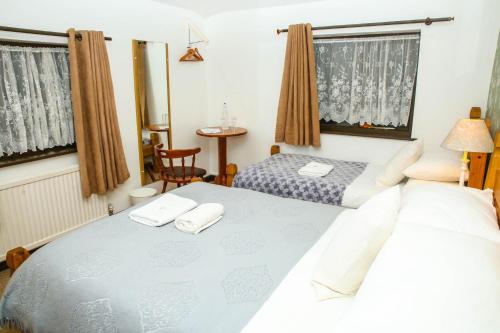 Un dormitorio con dos camas y una mesa. en New Gurkha Inn, en Brecon