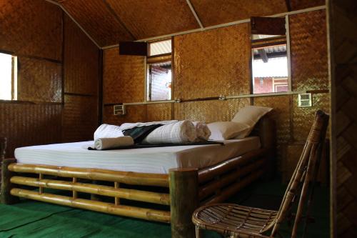 een bed in een kamer met 2 ramen en een stoel bij Nature Hunt Eco Camp in Kāziranga