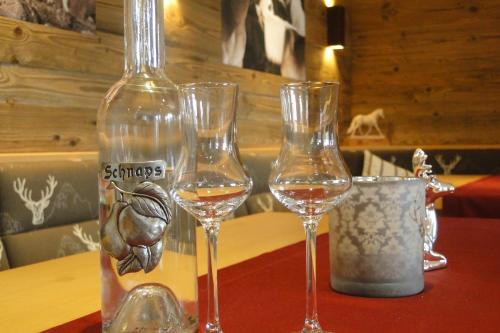 trzy kieliszki wina siedzące na stole obok butelki w obiekcie Denggnhof w mieście Münster