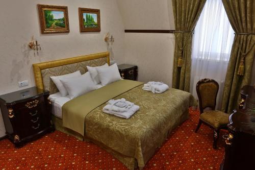 a bedroom with a bed with two towels on it at Hotel Ukraine Rivne in Rivne