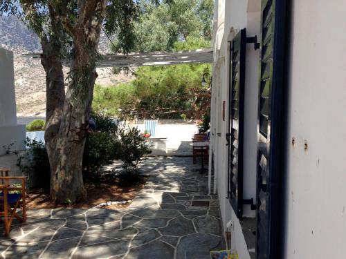 a door to a house with a tree and a walkway at House in Kamares - Sifnos in Kamarai