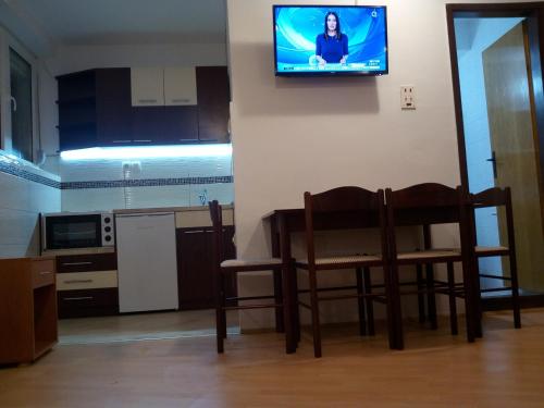 a kitchen with a table and chairs and a television on the wall at KOPAONIK-GONDOLA 100m in Brzeće