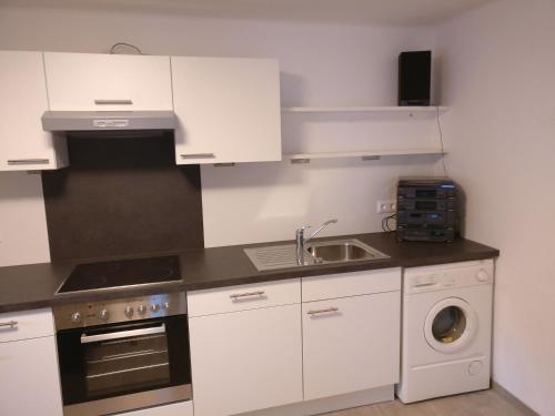 a white kitchen with a sink and a dishwasher at Appartement Schmidl in Flattach