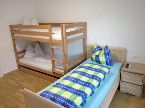 a bunk bed with a blue and yellow pillow at Appartement Schmidl in Flattach