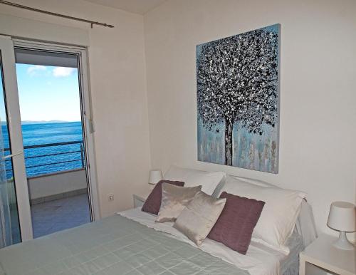 1 dormitorio con 1 cama y una pintura en la pared en Apartments Tila, en Drasnice