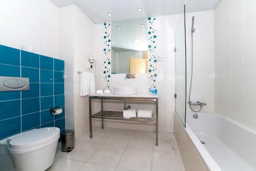 a bathroom with a toilet and a sink and a tub at Hotel Praia in Nazaré