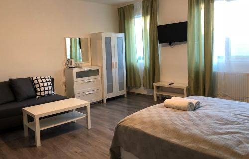 um quarto com uma cama, um sofá e uma cadeira em Terra Guest House em Velingrad