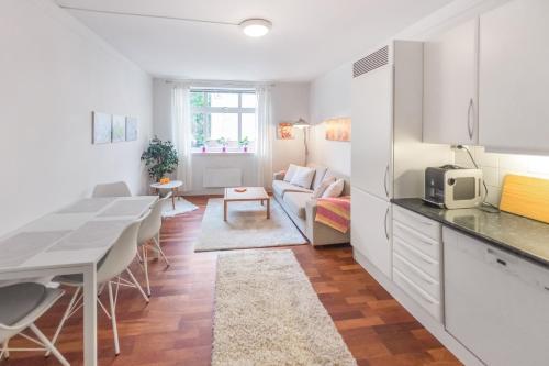a kitchen and living room with a table and a couch at Aalesund Apartments - Near Harbour in Ålesund
