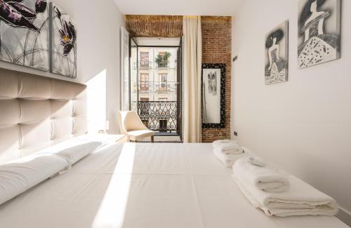 ein Wohnzimmer mit weißen Möbeln und einem Fenster in der Unterkunft Puerta Del Sol City Center II in Madrid