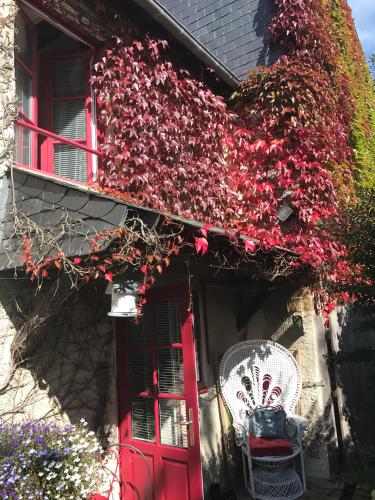 a red door on a house with flowers at Les chambres d'hôtes Le Val d'Honfleur in Équemauville