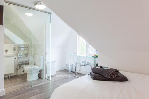 a white room with a bed and a bathroom at The Orlando in Cambridge