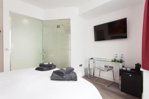 a room with a bed and a tv on a wall at The Orlando in Cambridge