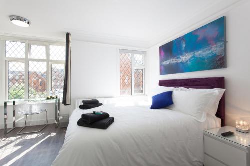 a white bedroom with a large white bed and windows at The Orlando in Cambridge