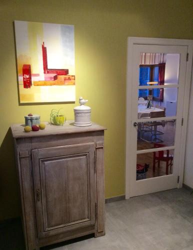 a room with a wooden cabinet and a door with a kitchen at La villa des Savoyards in Vielsalm
