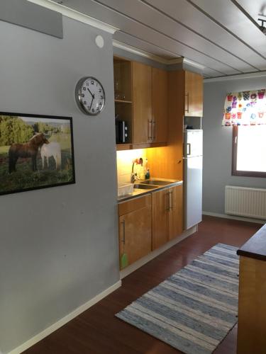 a kitchen with a clock on the wall at Utsikten in Borlänge