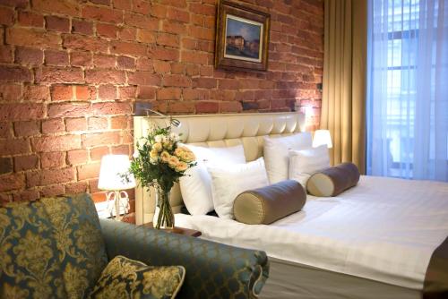 een slaapkamer met een bed en een bakstenen muur bij Galunov Hotel in Sint-Petersburg