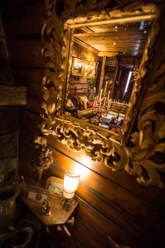 a mirror on a wooden wall with a candle on a table at Chalet BRAGARD in Limone Piemonte