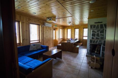 a living room with blue couches and a fireplace at Kuus-Hukkala in Harkala