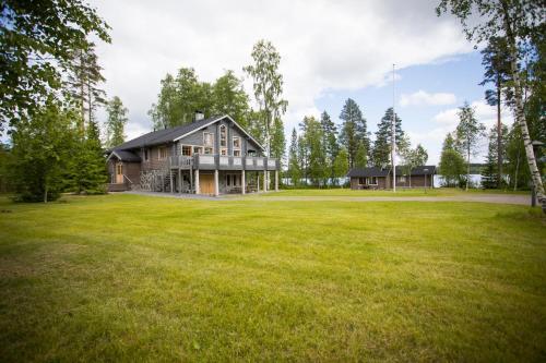 a large yard with a large house in a field at Kuus-Hukkala in Harkala