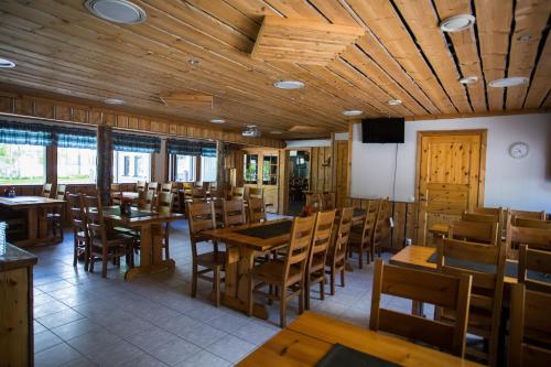 a dining room with wooden tables and chairs at Kuus-Hukkala in Harkala