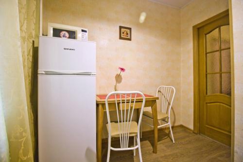モスクワにあるLakshmi Great Apartment VDNHのキッチン(テーブル、白い冷蔵庫付)