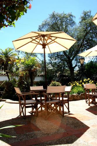 a wooden table and chairs with an umbrella at Hotel y Spa Getsemani in Villa de Leyva
