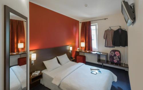 um quarto de hotel com uma cama grande e um espelho em Dodo Hotel em Riga