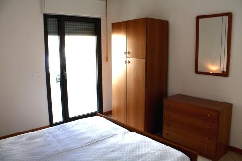 リニャーノ・サッビアドーロにあるApartment in Lignano Sabbiadoro 31384のベッドルーム1室(ベッド1台、ドレッサー、鏡付)