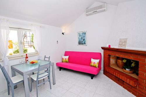 sala de estar con sofá rojo y mesa en Supetar Apartment City Center, en Supetar