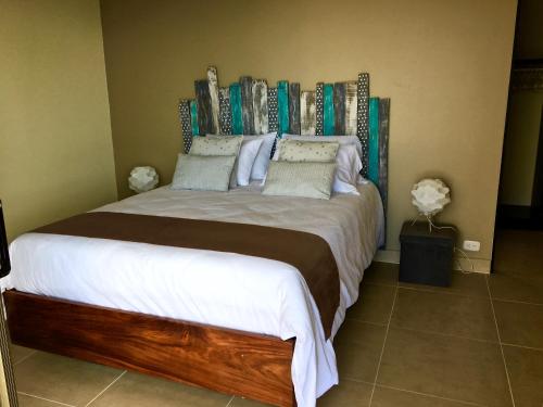 a bedroom with a large bed with a wooden headboard at Amazing ocean view Villa vista Chocoyas in Playa Flamingo