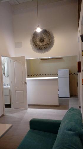 a living room with a green couch and a light at Acogedor Apartamento en Triana Sevilla in Seville