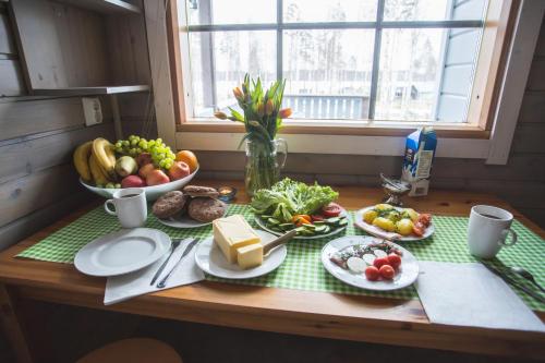 a table with plates of food and a bowl of fruit at Kuus-Hukkala in Harkala