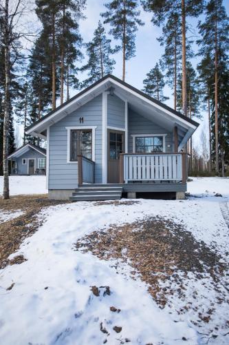 a small house with a porch in the snow at Kuus-Hukkala in Harkala